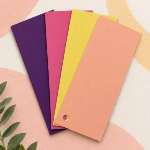 Vier fächerförmig angeordnete Farbmusterkarten in Violett, Pink, Gelb und Pfirsich auf hellem Hintergrund mit farbigen Pinselstrichen.